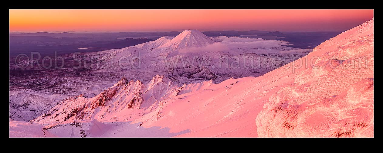 Image of Mount Ngauruhoe (2287m) from Mt Ruapehu at sunset. Pinnacle Ridge in foreground, Tama Lakes mid ground and Mt Tongariro (1967m) and Lake Taupo behind. Heavy winter snow. Panorama, Tongariro National Park, Ruapehu District, Manawatu-Wanganui Region, New Zealand (NZ) stock photo image