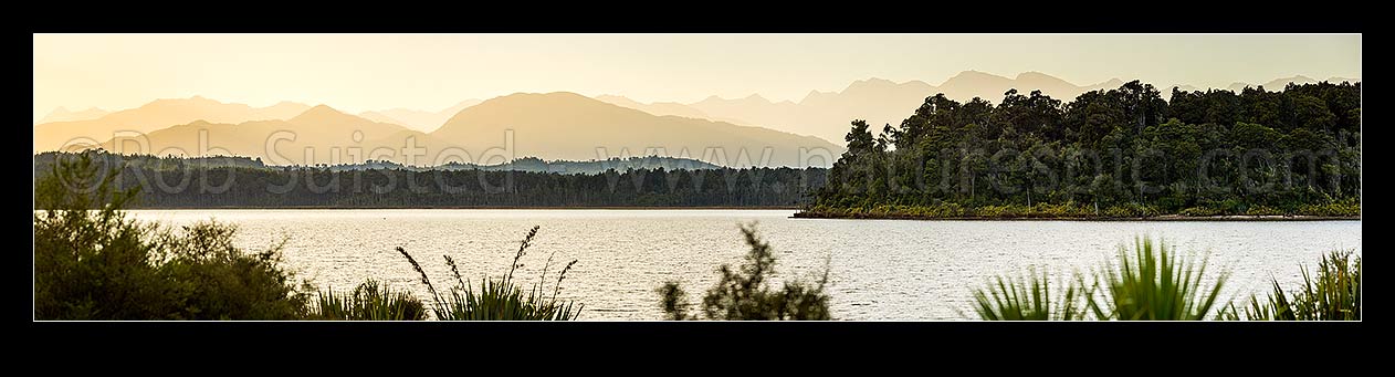 Image of Lake Mahinapua Scenic Reserve panorama at dawn, looking past Hobart Point and Picnic Bay to Mt Graham (829m) centre left and Southern Alps Main Divide in distance, Hokitika, Westland District, West Coast Region, New Zealand (NZ) stock photo image