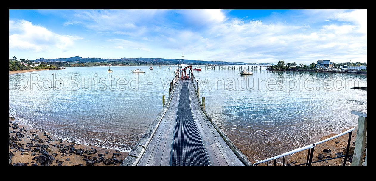 Image of Moeraki fishing fleet vessels moored in front of commercial wharf in Onekakara Bay on a calm morning. Panorama, Moeraki, Waitaki District, Canterbury Region, New Zealand (NZ) stock photo image