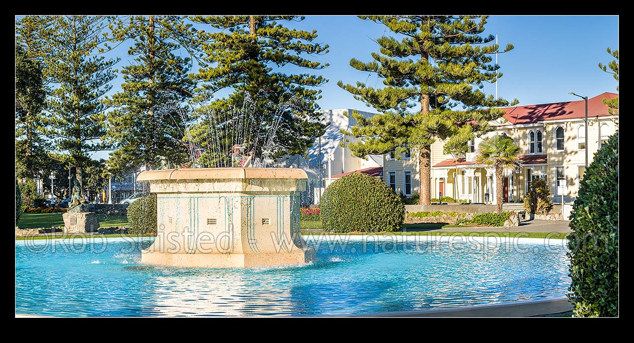 Image of Napier's iconic Tom Parker Art Deco fountain 1936, in Napier's warterfront gardens and marine parade. Pania of the Reef statue behind. Panorama, Napier, Napier City District, Hawke's Bay Region, New Zealand (NZ) stock photo image