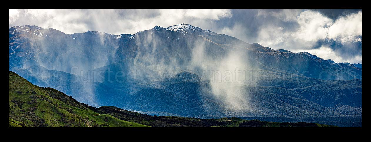 Image of Mount Titiroa (1715m) with spring snow showers falling in the Waiau River valley and slopes. Blackmount foreground. Panorama, Fiordland National Park, Southland District, Southland Region, New Zealand (NZ) stock photo image