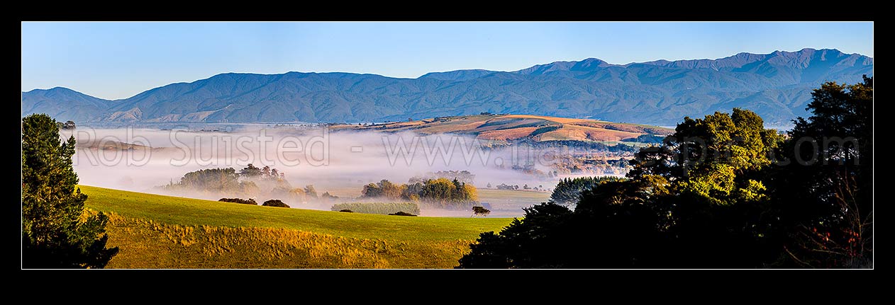 Image of Rural Gladstone morning panorama, with autumn colours and morning mist hanging in valleys. Tararua Ranges behind (Mt Hector 1529m far right). Panorama, Gladstone, Carterton District, Wellington Region, New Zealand (NZ) stock photo image