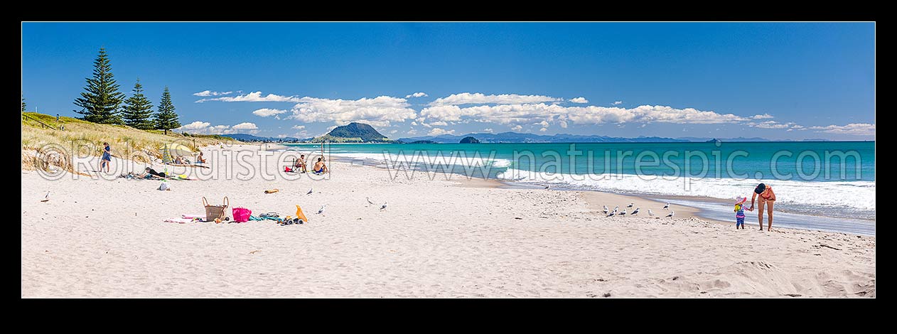 Image of Papamoa Beach on a summer day with people enjoying the summer sunshine. Looking west towards Mt Maunganui Mauao (231m). Panorama, Papamoa Beach, Tauranga District, Bay of Plenty Region, New Zealand (NZ) stock photo image