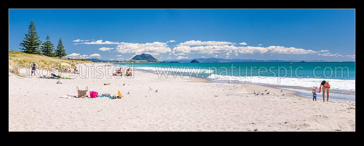 Image of Papamoa Beach on a summer day with people enjoying the summer sunshine. Looking west towards Mt Maunganui Mauao (231m). Panorama, Papamoa Beach, Tauranga District, Bay of Plenty Region, New Zealand (NZ) stock photo image