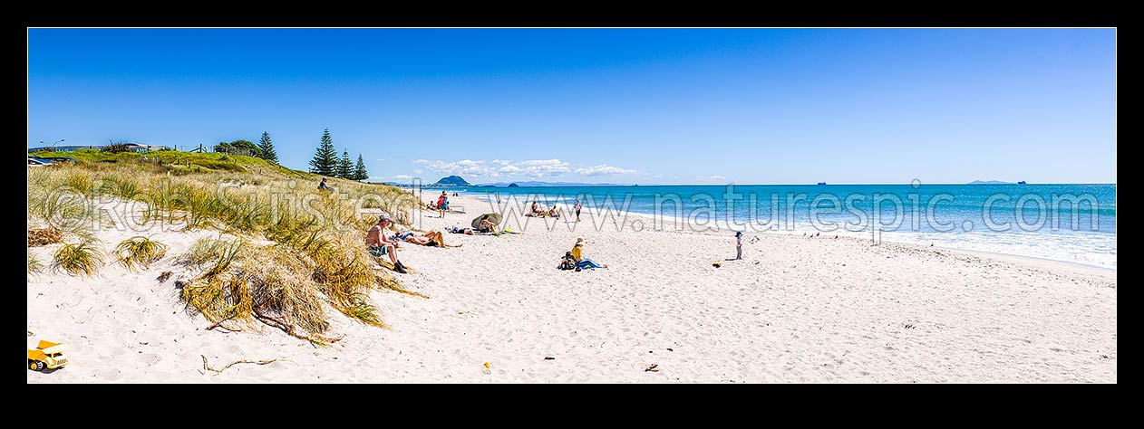 Image of Papamoa Beach on a summer day with people enjoying the summer sunshine. Looking west towards Mt Maunganui Mauao (231m). Panorama, Papamoa Beach, Tauranga District, Bay of Plenty Region, New Zealand (NZ) stock photo image