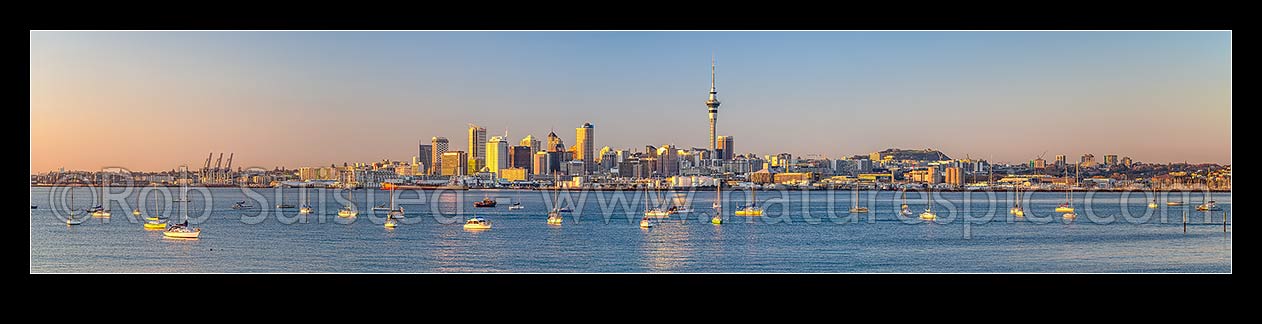 Image of Auckland City Skyline, CBD, and moored sailboats, seen from across the Waitemata Harbour on a calm morning. Panorama as golden sun lights the city at dawn. Similar 53156, Auckland, Auckland City District, Auckland Region, New Zealand (NZ) stock photo image